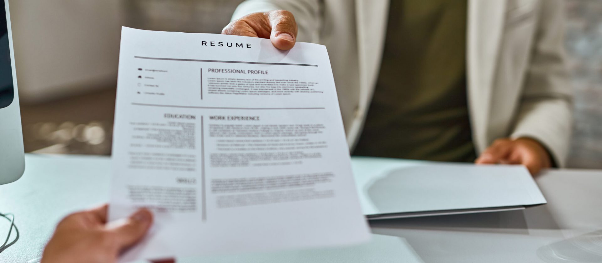 Close-up of job applicant giving his resume during job interview in the office.